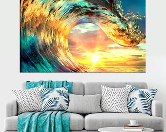 Puede incluir: Un gran lienzo que representa una ola rompiendo en el océano. La ola es una mezcla de tonos turquesa, dorados y azules, con el sol poniéndose en el fondo. La obra de arte se exhibe sobre un sofá gris con cojines decorativos y una manta turquesa.