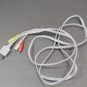 May include: White AV cable with a multi-pin connector and three RCA connectors in yellow, red, and white. The cable is coiled and ready for use. This cable is designed for audio and video connections.