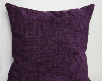 May include: A deep purple square throw pillow with a textured fabric.