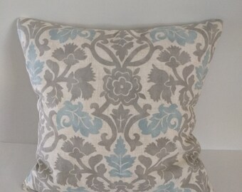 May include: A decorative throw pillow with a white background and a blue and gray floral pattern.