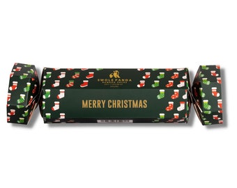May include: A Christmas cracker-style gift box with a dark green background and a pattern of red, green, and white stockings. The box reads "MERRY CHRISTMAS" in gold lettering. The brand name "SWOLE PANDA" is also visible.