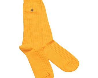 May include: A pair of bright yellow ribbed socks. The socks have a small, dark brown embroidered emblem near the top. The socks are made of a soft material and are designed to be worn on the feet.