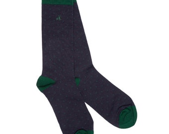May include: A pair of dark blue socks with a green top and small white dots. The socks have a green trim around the top and bottom.