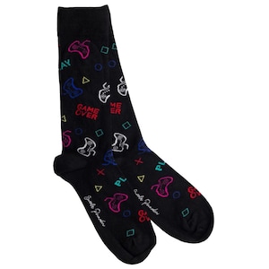 May include: Black socks featuring a repeating pattern of colourful video game controllers, geometric shapes, and the words "GAME OVER" and "PLAY". A fun accessory for gamers.