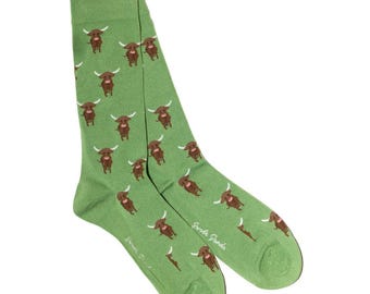 May include: A pair of green socks with a repeating pattern of brown Highland cows. The socks have a ribbed cuff and a smooth footbed. The text "Sweet Panda" is printed on the side of each sock.
