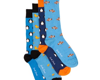 May include: A set of four pairs of colorful socks with different animal designs. The socks feature penguins, fish, and yellow ducks. The socks are blue, orange, and navy blue.