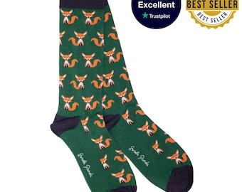 May include: A pair of green socks with a repeating pattern of orange foxes. The socks have navy blue heels, toes, and cuffs. The text "Swede Panda" is printed on the bottom of each sock. A "Best Seller" badge and a "Rated Excellent" badge are also visible.
