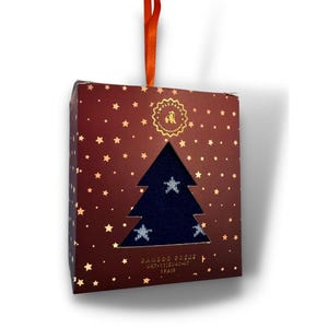 May include: A red box with gold stars and a cut-out of a blue sock with white stars. The box has a red ribbon and the text "BAMBOO SOCKS UK7-11/EU41-45 1 PAIR" on the bottom.