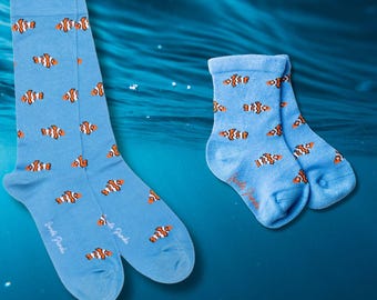 May include: Two pairs of blue socks with a repeating pattern of orange and white clownfish. One pair is knee-high, and the other is ankle-length. The socks have the text "Jungle Panda" printed on them.
