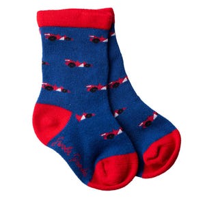 May include: A pair of blue socks with a red racing car pattern. The socks have red cuffs and red toes.