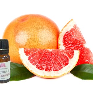 May include: A 10 ml bottle of ruby grapefruit fragrant oil with a pink flower logo. The bottle is next to a whole grapefruit and several slices of grapefruit.