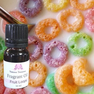 May include: A small brown glass bottle with a black cap. The bottle contains a fragrant oil with the label "Natures Treasures Fragrant Oil Fruit Loops 10 ml". The bottle is sitting on a bowl of colourful cereal loops in milk.