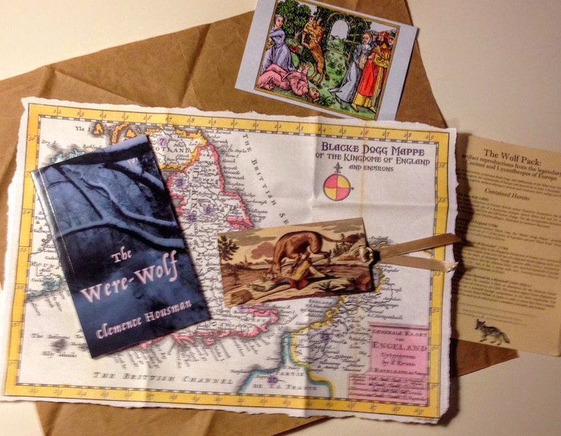 May include: A vintage map of England with a book titled "The Were-Wolf" by Clemence Housman, a small postcard with a wolf illustration, and a pamphlet titled "The Wolf Pack: Perfect reproductions from the legendary illustrations and landscapes of Europe."