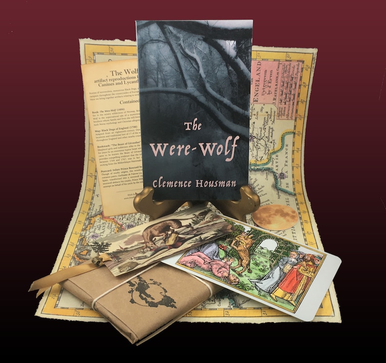 May include: A vintage-style book titled "The Were-Wolf" by Clemence Housman, with a dark forest scene on the cover. The book is displayed on a wooden stand, surrounded by a map, a tarot card, and a small decorative box.