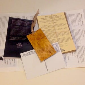 May include: A set of vintage postcards featuring a wolf pack, a fox, and a dog. The postcards are printed on thick paper with a textured surface. The text on the postcards reads "The Wolf Pack" and "The Fox".