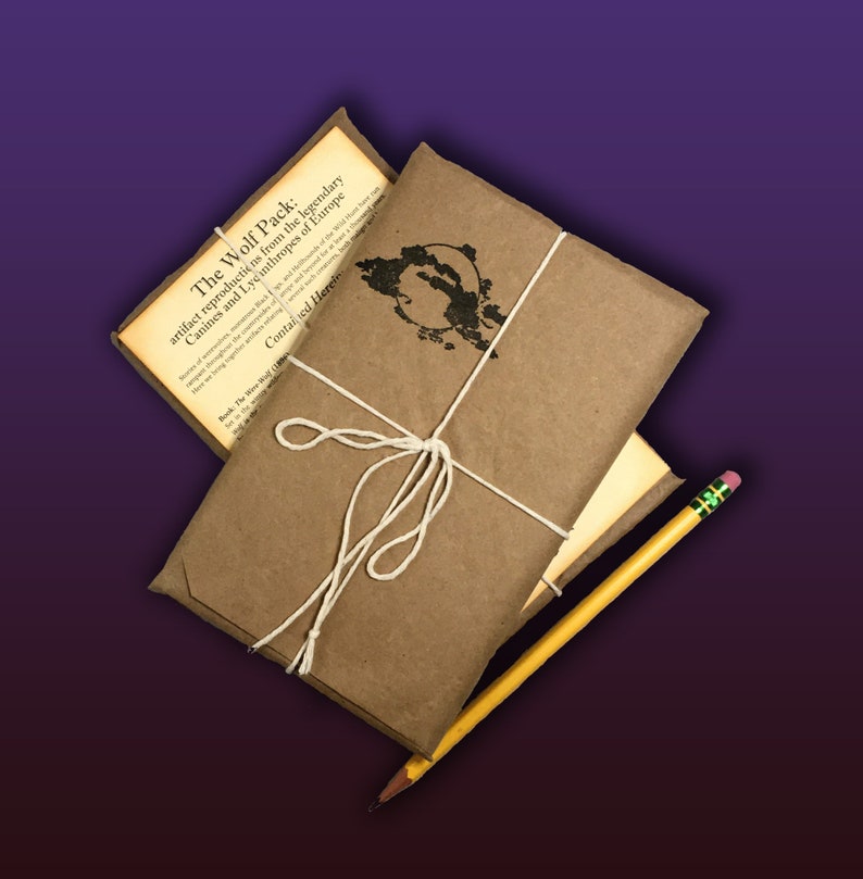 May include: A brown paper package tied with twine and a yellow pencil. The package is labeled "The Wolf Pack: artifact reproductions from the legendary Canines and Lycinthropes of Europe. Contained Herein."