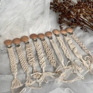 以下が含まれることがあります： マクラメストラップが付いた、手作りの木製ベビー用歯固め10個セット。歯固めは天然木製で、ストラップはコットンコード製です。歯固めは様々なデザインと色があります。
