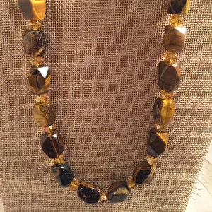 Necklaceis made with large brown and yellow Gemstones and yellow beads.