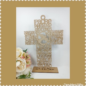 May include: A wooden cross with the Lord's Prayer in Spanish written on it. The cross is freestanding and has a dove cutout in the center.