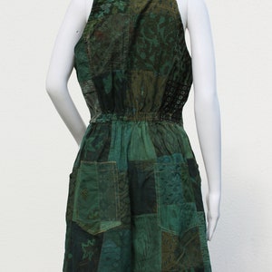 May include: A green patchwork jumpsuit with a halter neckline and a drawstring waist. The jumpsuit is made of different fabrics with floral and paisley patterns.