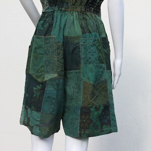 May include: Green patchwork shorts with a drawstring waist and pockets. The shorts are made of different fabrics with floral and geometric patterns.