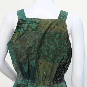 May include: Green patchwork jumpsuit with adjustable straps. The fabric has a floral pattern.