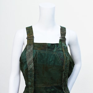 May include: Green patchwork dungarees with adjustable straps and a square neckline.