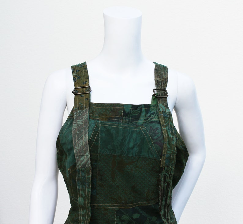 May include: Green patchwork dungarees with adjustable straps and a square neckline.