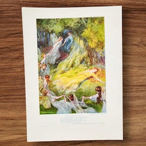 Op de afbeelding: Een rechthoekige print met een kleurrijke illustratie van verschillende gevleugelde figuren in een bosrijke omgeving, waarbij één figuur in een gele jurk op het gras ligt. Onder de illustratie staat de tekst THE FAIRIES' SONG, gevolgd door verzen.