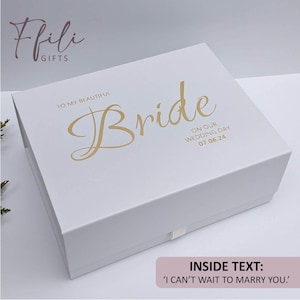 May include: A white gift box with gold text reading "To My Beautiful Bride" and "On Our Wedding Day 07.06.24". The box has a pull tab and the text "Inside Text: 'I can't wait to marry you.'". A wedding-themed gift.