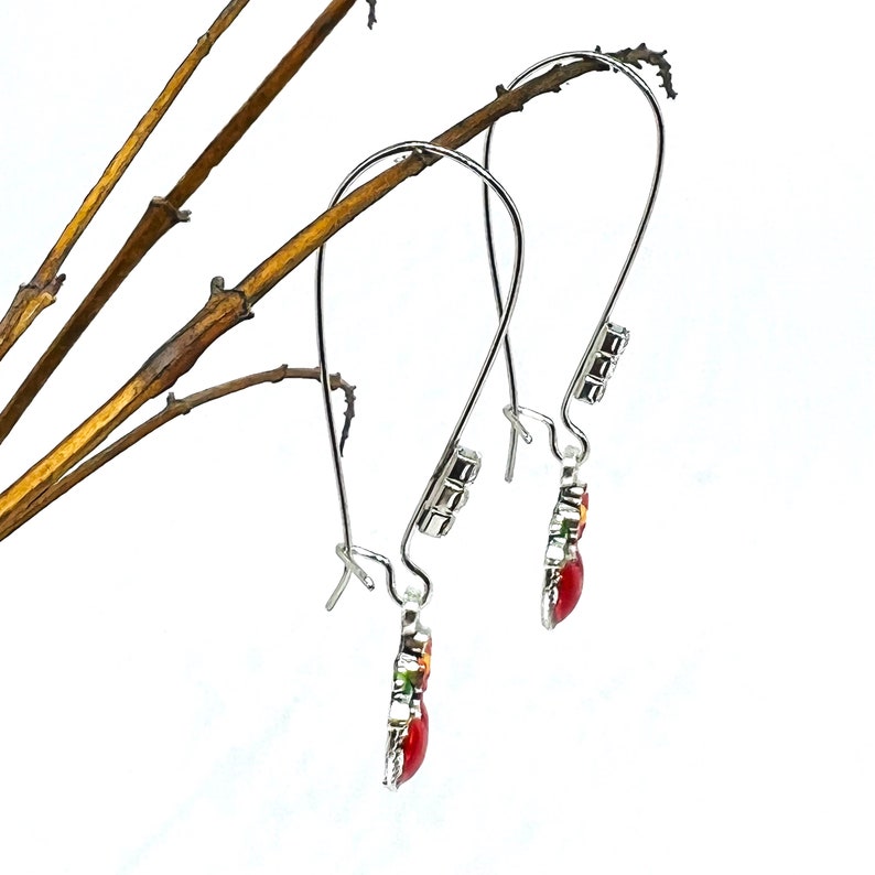 Peut inclure: Une paire de boucles d'oreilles pendantes en argent avec des motifs floraux rouges, verts et jaunes et des accents de cristal transparent.