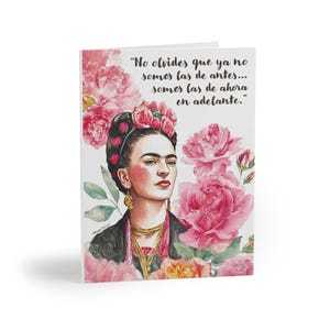 Könnte beinhalten: Grußkarte mit einem Aquarellporträt von Frida Kahlo, umgeben von rosa Blumen. Die Karte enthält das Zitat: "No olvides que ya no somos las de antes... somos las de ahora en adelante."
