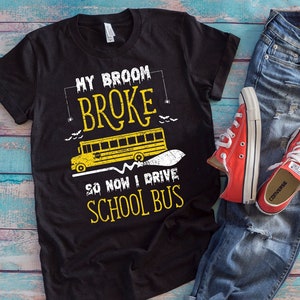 Puede incluir: Camiseta negra con un gráfico de un autobús escolar y el texto "My broom broke so now I drive school bus".