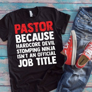 May include: Black t-shirt with white text that reads "PASTOR BECAUSE HARDCORE DEVIL STOMPING NINJA ISN'T AN OFFICIAL JOB TITLE".