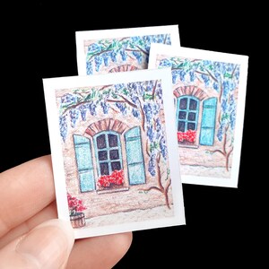 Peut inclure: Trois cartes blanches avec une illustration dessinée à la main d'une fenêtre avec des volets bleus et une vigne de fleurs violettes. La fenêtre est sur un bâtiment avec une façade beige.