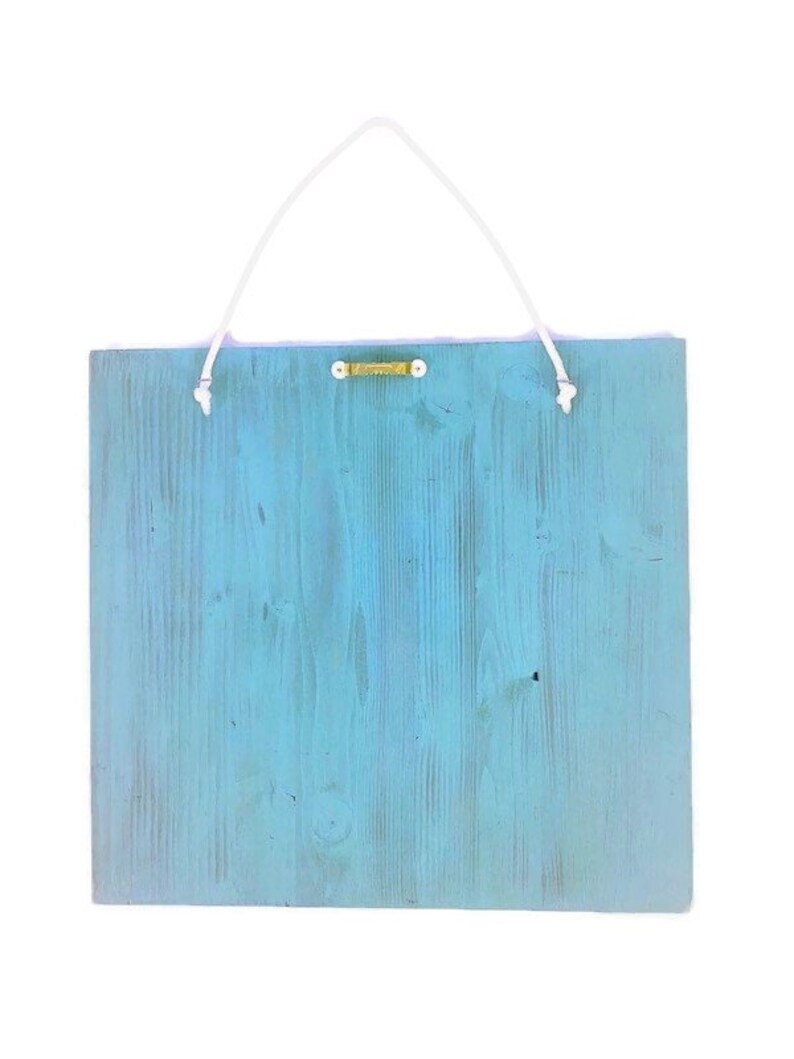 Puede incluir: Un letrero de madera azul claro con un colgador de cuerda blanca. El letrero est&aacute; en blanco y listo para ser personalizado.