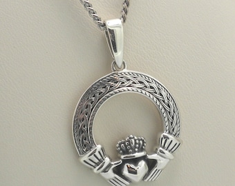 May include: A silver Claddagh pendant necklace. The pendant features a heart, crown, and hands design within a circular frame with Celtic knotwork. The necklace chain is also silver.