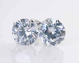 May include: A pair of silver stud earrings with clear round cubic zirconia stones.