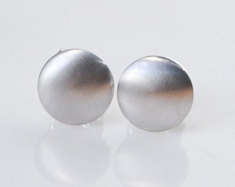 May include: A pair of silver stud earrings with a smooth, round shape.