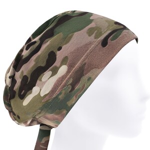 Op de afbeelding: Een operatiemuts met een camouflagepatroon in tinten olijfgroen, donkerbruin, beige en zwart. Het hoofddeksel heeft een brede, gestikte band over het voorhoofd en stoffen linten aan de achterzijde voor een stevige pasvorm rond het hoofd.