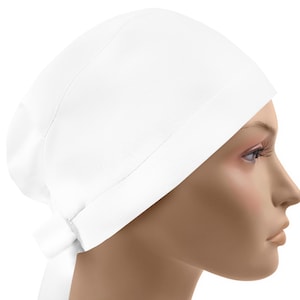 May include: A solid white scrub cap featuring a wide, folded front band and a tie-back closure at the nape of the neck. The head covering is constructed from a smooth, opaque fabric and is designed to fit securely around the head with a rounded crown.
