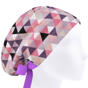May include: A pink, purple, and black geometric patterned scrub hat with a purple tie.