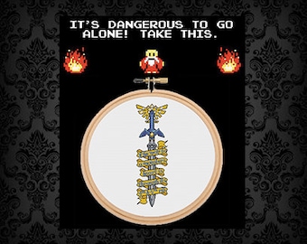 May include: A white embroidery hoop with a blue and gold sword design. The sword has a yellow inscription that reads "It's dangerous to go alone! Take this."
