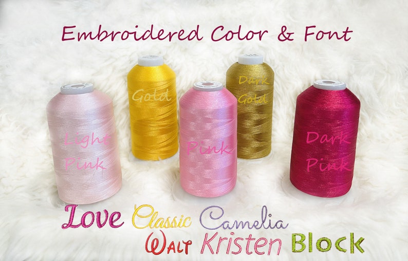Pode incluir: Cinco carret&eacute;is de fio para bordar em diferentes cores: rosa claro, dourado, dourado escuro, rosa e rosa escuro. Os carret&eacute;is s&atilde;o etiquetados com os nomes das cores. O texto "Embroidered Color & Font" est&aacute; na parte superior da imagem. O texto "Love Classic Camelia WALT Kristen Block" est&aacute; na parte inferior da imagem.