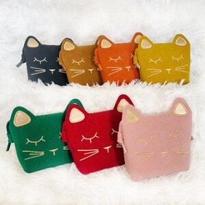 May include: Set of eight felt cat-shaped purses in various colours, including black, brown, orange, yellow, green, red, pink, and gold. Each purse has a gold embroidered cat face with closed eyes and whiskers.