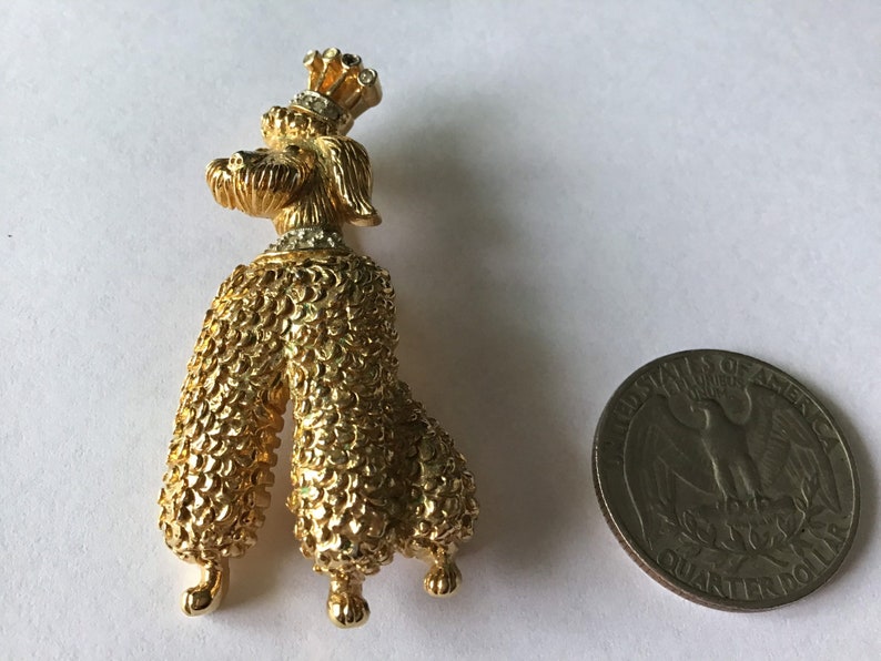 Designer signed Jomaz Goldtone poodle brooch wearing a crown and collar encrusted with crystal Textured metal fur detail.