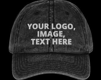 Op de afbeelding: Zwarte, verweerde denim baseballcap met witte geborduurde tekst die "YOUR LOGO, IMAGE, TEXT HERE" luidt.