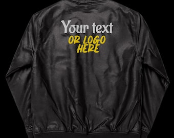 Puede incluir: Chaqueta bomber de cuero negro con un diseño bordado en blanco que dice "Your text or logo here" en amarillo.