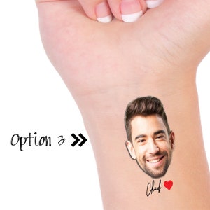 May include: A temporary tattoo featuring a man's face with a smiling expression. The tattoo also includes the name "Chad" and a red heart.