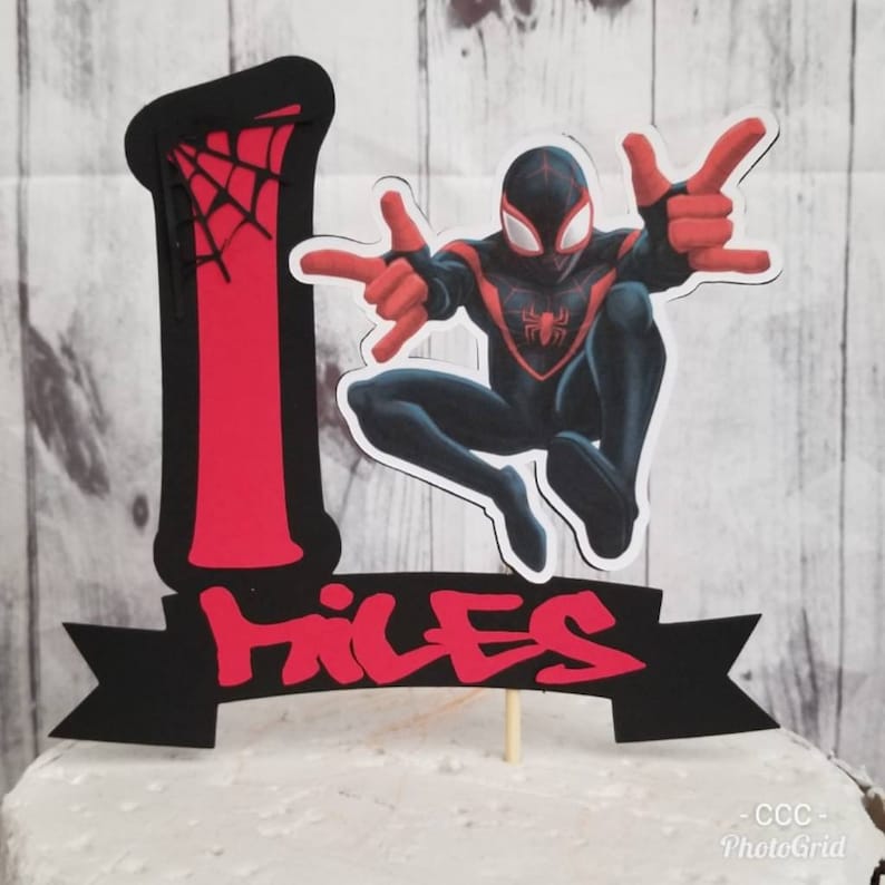 May include: Black and red Spider-Man cake topper with a web design and the number 1. The topper also includes the name "Miles" in red and black letters.